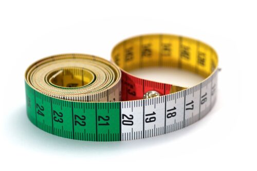 A colorful soft sewing tape measure curled on a surface